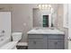 Bathroom featuring double vanities, a large mirror, tub with shower, and modern flooring at 6755 Biscayne Blvd, Rex, GA 30273