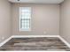 Cozy bedroom with light gray walls, wood floor, and window with white trim at 6755 Biscayne Blvd, Rex, GA 30273
