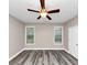 Spacious bedroom featuring a ceiling fan, natural light from two windows, and modern flooring at 6755 Biscayne Blvd, Rex, GA 30273