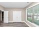Open bedroom featuring a large window, blinds, and wood floors at 6755 Biscayne Blvd, Rex, GA 30273