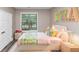 Bright bedroom featuring wood floors, a window, and playful decor for a cozy atmosphere at 6755 Biscayne Blvd, Rex, GA 30273