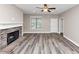 Spacious living room featuring a stone fireplace, ceiling fan, and sleek, modern flooring at 6755 Biscayne Blvd, Rex, GA 30273