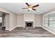 Bright living room featuring a stone fireplace, modern ceiling fan, and stylish wood-look flooring at 6755 Biscayne Blvd, Rex, GA 30273