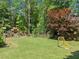 Spacious backyard with lush lawn, playground, mature trees, and a soccer goal for outdoor activities at 940 Kinghorn Nw Dr, Kennesaw, GA 30152