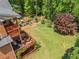 Expansive backyard featuring a large grassy area, wooden deck, play area and mature trees at 940 Kinghorn Nw Dr, Kennesaw, GA 30152