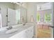 Bright bathroom featuring double vanity, mirror and doorway view to bedroom creating an elegant and functional space at 940 Kinghorn Nw Dr, Kennesaw, GA 30152