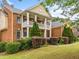 Charming brick home with a two-story porch and well-kept lawn, surrounded by lush landscaping at 940 Kinghorn Nw Dr, Kennesaw, GA 30152