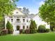 Elegant two-story home painted in white, with a charming porch and meticulously maintained landscaping at 940 Kinghorn Nw Dr, Kennesaw, GA 30152