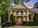 Two-story brick home featuring a cozy porch and well-maintained landscaping against a dusk sky at 940 Kinghorn Nw Dr, Kennesaw, GA 30152
