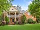 Beautiful two-story brick home with a welcoming front porch and manicured landscaping at 940 Kinghorn Nw Dr, Kennesaw, GA 30152