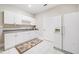 Bright kitchenette featuring white cabinets, granite countertops, tile flooring, and modern appliances at 940 Kinghorn Nw Dr, Kennesaw, GA 30152
