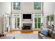 This well-lit living room features a fireplace, French doors, large windows, and a comfortable leather sofa at 940 Kinghorn Nw Dr, Kennesaw, GA 30152