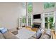 Bright living room with a fireplace, French doors, and large windows that enhance the natural light and views at 940 Kinghorn Nw Dr, Kennesaw, GA 30152