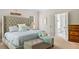 Bright main bedroom boasts a tufted headboard, sitting bench, and ensuite bathroom access at 940 Kinghorn Nw Dr, Kennesaw, GA 30152