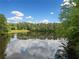 Scenic view of a tranquil pond reflecting the sky, surrounded by lush green trees at 940 Kinghorn Nw Dr, Kennesaw, GA 30152