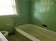 Bathroom with green tile walls, a bathtub, and fixtures at 1235 Westboro Sw Dr, Atlanta, GA 30310