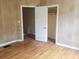 This bedroom features hardwood floors, wood paneled walls, and a closet at 1235 Westboro Sw Dr, Atlanta, GA 30310