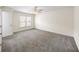Spacious bedroom features neutral walls, gray carpet, natural light from a window, and a ceiling fan at 238 Chads Ford Way, Roswell, GA 30076