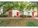 Exterior view of townhomes featuring colorful doors, tidy landscaping, and a lush green space in front at 238 Chads Ford Way, Roswell, GA 30076