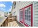 Exterior view of unit deck with bright red framed glass doors, wood railings, and siding at 238 Chads Ford Way, Roswell, GA 30076