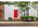 Close-up exterior showing front door with a vibrant red door, complemented by neat shrubs and siding at 238 Chads Ford Way, Roswell, GA 30076