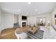 Living room with wood floors, a cozy fireplace, staircase, and open dining area at 238 Chads Ford Way, Roswell, GA 30076