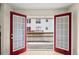 View from the unit through red-framed glass doors out to the unit's deck and parking area at 238 Chads Ford Way, Roswell, GA 30076