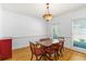 Bright dining room featuring hardwood floors, elegant wainscoting, and a unique chandelier, complemented by natural light from large windows at 2651 Briarlake Ne Rd, Atlanta, GA 30345