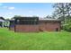 Backyard view of brick home with screened porch, grassy lawn and mature trees at 2738 Westchester Dr, Atlanta, GA 30344