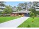 Charming red brick home with a newly paved driveway, complemented by lush green lawn and trees at 2738 Westchester Dr, Atlanta, GA 30344