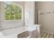 Bathroom showcases a large tub with tiled backsplash and a large window for natural light at 4129 Flakes Mill Manor Ln, Ellenwood, GA 30294