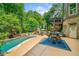 Extensive backyard with pool, hot tub, fireplace, patio dining area, lush greenery, and a serene atmosphere at 106 Stephens Farm Dr, Canton, GA 30115