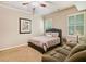 Cozy bedroom featuring a queen-size bed, comfortable sofa, and natural light from the shuttered windows at 106 Stephens Farm Dr, Canton, GA 30115
