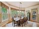 Formal dining room with a wooden table, elegant chandelier, and large windows with wooden shutters at 106 Stephens Farm Dr, Canton, GA 30115