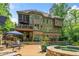Expansive home exterior features a large patio, inviting pool, and lush landscaping at 106 Stephens Farm Dr, Canton, GA 30115