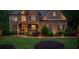 Exterior view of a well-lit home with stone and brick accents, a front porch, and landscaped yard at 106 Stephens Farm Dr, Canton, GA 30115