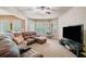 Spacious living room features a large sectional sofa, bay windows, and a modern entertainment center at 106 Stephens Farm Dr, Canton, GA 30115