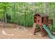 Backyard playhouse with slide, climbing wall and fire pit provides a fun and adventurous space for  at 106 Stephens Farm Dr, Canton, GA 30115