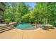 Beautiful backyard pool with mature trees, a built-in hot tub, and a flagstone pool deck with steps leading into the water at 106 Stephens Farm Dr, Canton, GA 30115