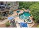 Backyard oasis with a freeform pool, spa, outdoor dining, fireplace, and lush landscaping at 106 Stephens Farm Dr, Canton, GA 30115