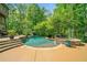 Beautiful swimming pool with attached spa, slide, and stone accents creates a luxurious outdoor living space at 106 Stephens Farm Dr, Canton, GA 30115