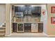 This home features a well-appointed wet bar with granite counters, tile backsplash, wine rack, and under-counter beverage fridge at 106 Stephens Farm Dr, Canton, GA 30115