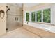 Bright bathroom with a soaking tub under a window and a separate glass-enclosed shower at 5105 Jett Forest Trl, Atlanta, GA 30327