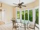Bright breakfast area with floor to ceiling windows, modern ceiling fan and glass dining table at 5105 Jett Forest Trl, Atlanta, GA 30327