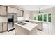 Eat-in kitchen features a gas cooktop on the island, stainless steel refrigerator, and bright windows at 5105 Jett Forest Trl, Atlanta, GA 30327