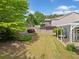 Lush backyard with green grass, mature trees, and a pergola covered patio for outdoor relaxation at 1435 Harburn Ct, Cumming, GA 30041