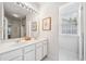 Bathroom featuring double sinks, bright lighting and white cabinetry and fixtures at 1435 Harburn Ct, Cumming, GA 30041