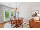 Bright dining area with hardwood floors, stylish chandelier, and views of the backyard through french doors at 1435 Harburn Ct, Cumming, GA 30041