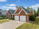 Brick home with a dark roof, 2-car garage, and a large driveway at 1435 Harburn Ct, Cumming, GA 30041