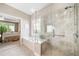 Modern main bathroom with a glass shower, large tub, and decorative window adding a touch of elegance at 1435 Harburn Ct, Cumming, GA 30041